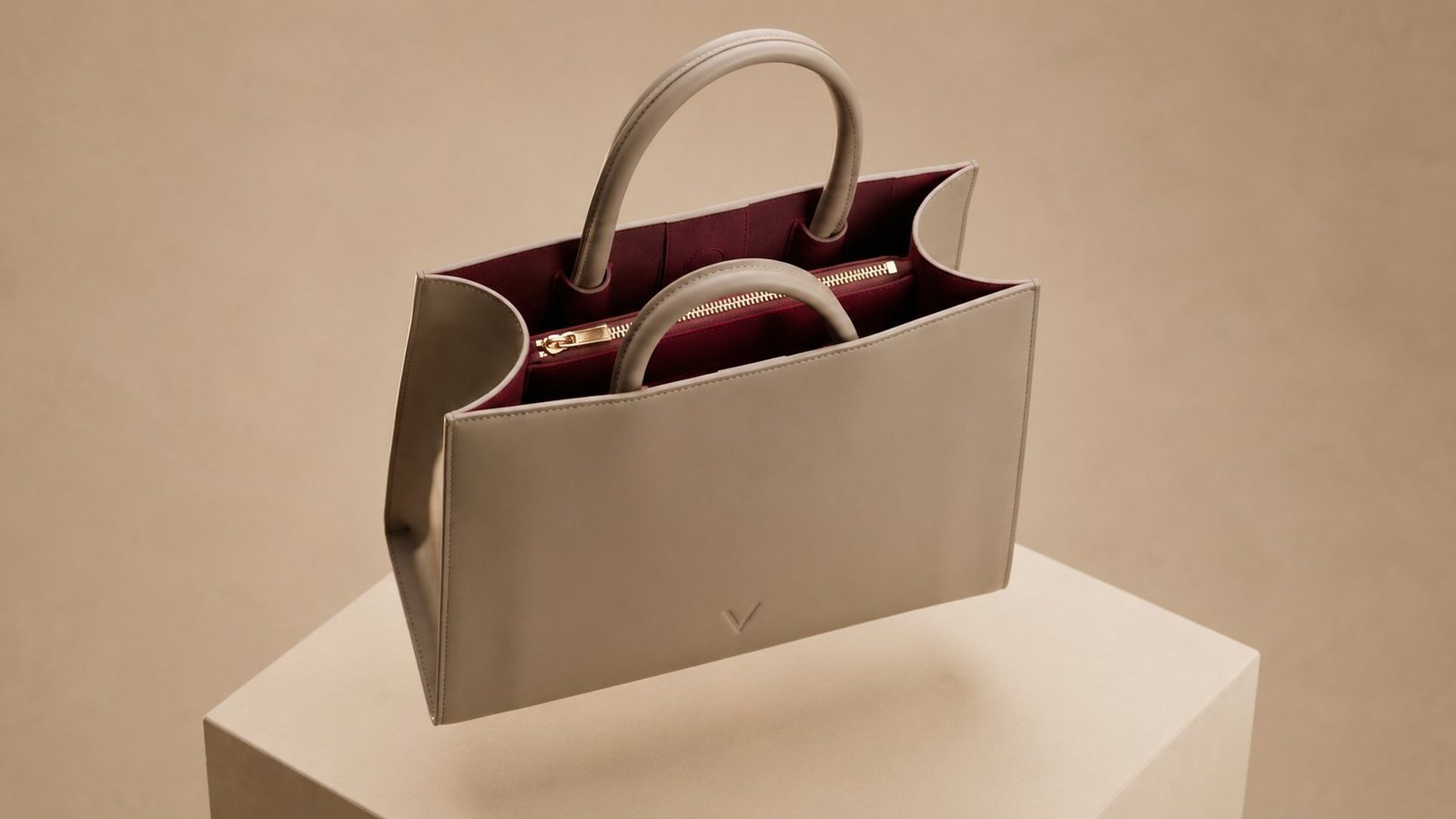 Looking down into the open tote: dark burgundy suede lining, multiple compartments and interior pockets.